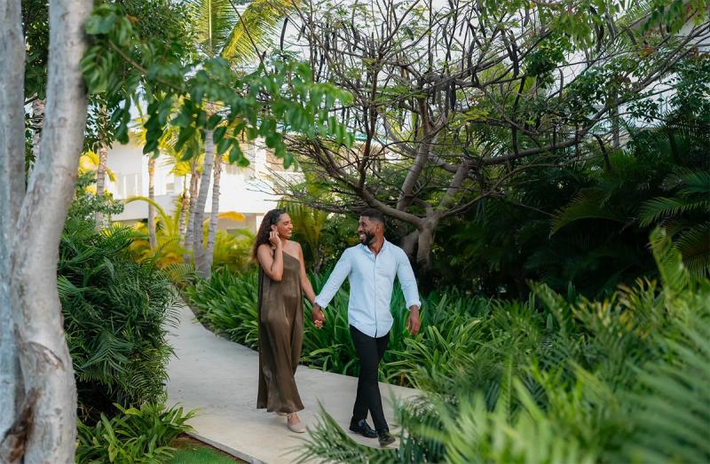 Pareja disfrutando de un sendero tropical en Playa Esmeralda, Miches