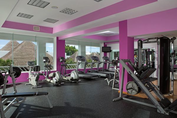 Área de entrenamiento con equipos modernos y pesas en Secrets Playa Esmeralda Resort & Spa